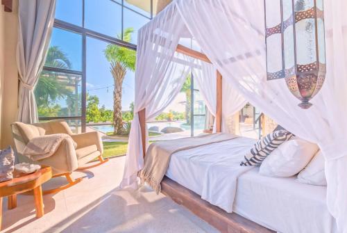 ein Schlafzimmer mit einem Bett und einem großen Fenster in der Unterkunft The Castle Uluwatu - Ocean View Luxury villa in Uluwatu
