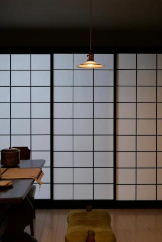 a room with a large window with a table and a light at Tonoda Guesthouse Kyoto 殿田宿 Private 2-Story Home in Kyoto