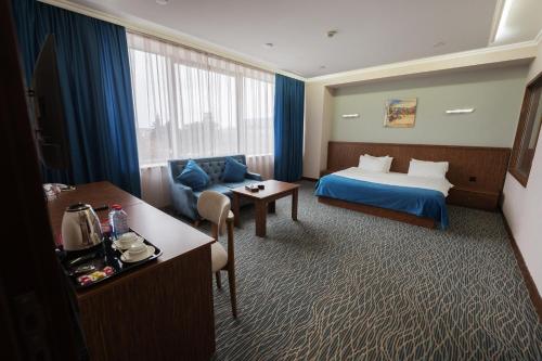 a hotel room with a bed and a couch at Innab Inn Hotel in Baku