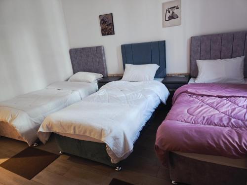 ein Zimmer mit drei Betten in einem Zimmer in der Unterkunft ARK Luxury Rooms walking Distance to Ferrari world, Yas Island in Yas Island