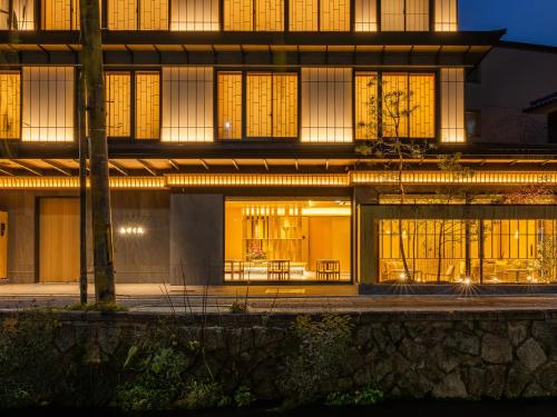 a building with lit up windows at night at AKEKURE Kyoto Shirakawa in Kyoto