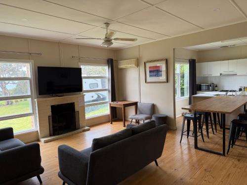 a living room with a fireplace and a table and chairs at Cooinda Retreats - The Residence in Victor Harbor