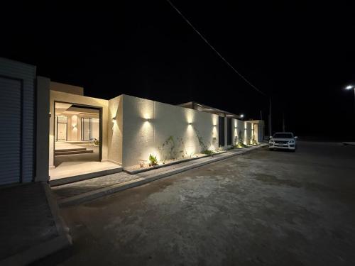 una fila di case di notte con un'auto parcheggiata fuori di شاليه وجد a Shaqra