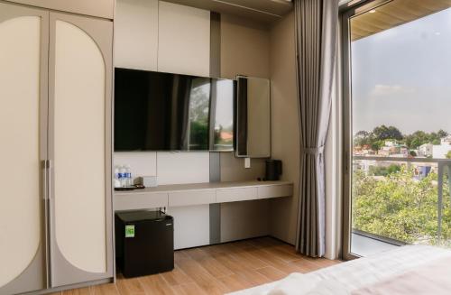 um quarto com uma cama e uma janela grande em Petit Hotel em Thu Dau Mot