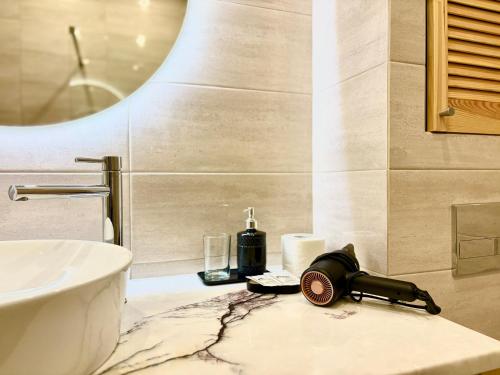 a bathroom with a sink and a shower with a fan at Lux Garden Appartments in Kharkiv