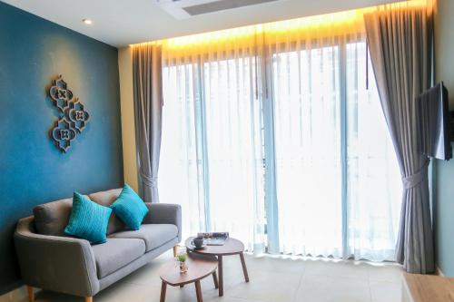 a living room with a couch and a large window at Fusion Suites Phuket Patong in Patong Beach