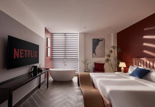 um quarto de hotel com uma cama e uma banheira em Lovera Hotel Airport em Cidade de Ho Chi Minh