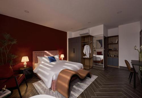 um quarto com uma grande cama branca e uma cadeira em Lovera Hotel Airport em Cidade de Ho Chi Minh
