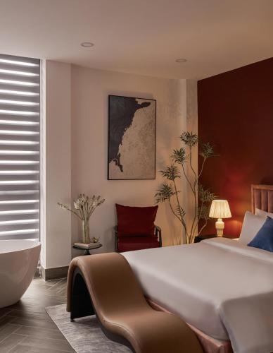 a bedroom with a large bed and a bath tub at Lovera Hotel Airport in Ho Chi Minh City