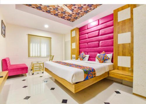 印多尔HOTEL SiGNOR的一间卧室设有一张大床和粉红色的墙壁