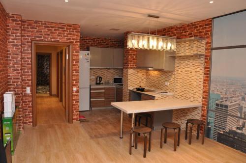 a kitchen with a brick wall and a table and stools at ART Hostel in Almaty