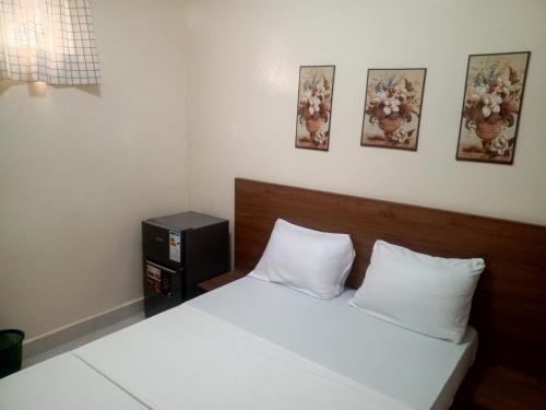ein Schlafzimmer mit einem Bett und drei Bildern an der Wand in der Unterkunft Résidence Keur Mame Seye 3 in Dakar