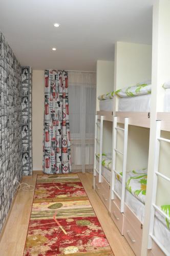 a room with bunk beds and a rug at ART Hostel in Almaty