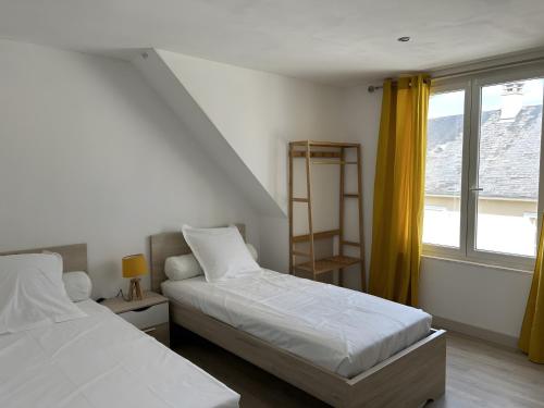 Un dormitorio con dos camas y una ventana. en Gîte Le Rabelais, en Thésée