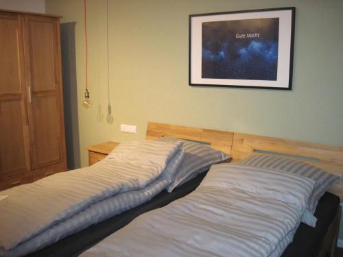 twee bedden in een slaapkamer met een foto aan de muur bij Urlaub bei Alma in Wurster Nordseeküste