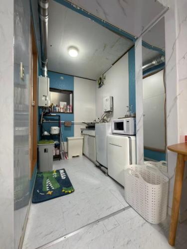 a kitchen with blue walls and white appliances at 和風客棧 in Tokyo