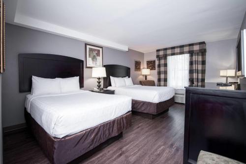 a hotel room with two beds and a window at Carradoc Hall Hotel & Conference Center by The Red Collection in Leesburg