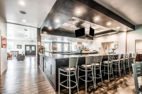 a bar with stools in a large room at Carradoc Hall Hotel & Conference Center by The Red Collection in Leesburg