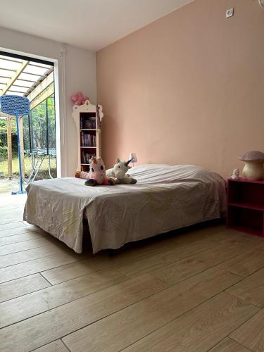 two stuffed animals sitting on a bed in a bedroom at Kaz coco mango in Basse-Terre
