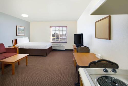 a small hotel room with a bed and a couch at WoodSpring Suites Baton Rouge Airline Highway in Baton Rouge