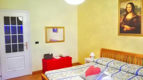 1 dormitorio con 1 cama y una pintura en la pared en Luna del Belvedere, en Asti