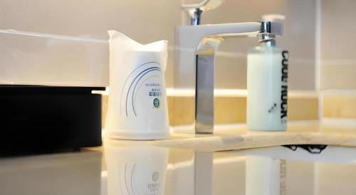 City Comfort Inn Chengdu Wenjiang University Town Fengxi River Metro Station في تشنغدو: زجاجتان من الروائح تقعان على منضدة بجوار حوض