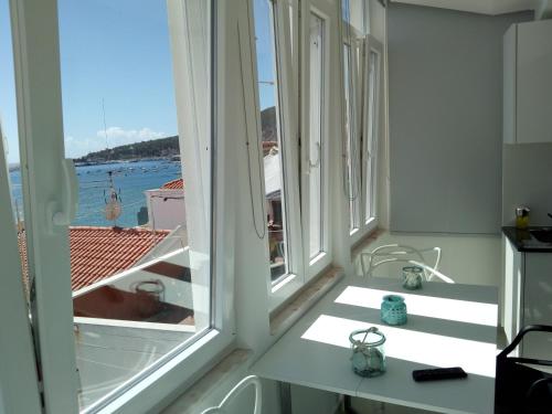 a room with windows with a view of the ocean at SeaShell Apartment - Sesimbra in Sesimbra
