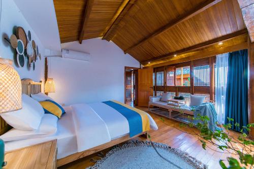 En eller flere senge i et værelse på LiJiang Sunshine Garden Villa