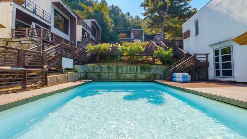 a swimming pool in the backyard of a house at Hongcheon inmylife dokche pension in Hongcheon