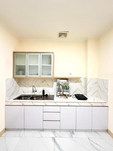 a kitchen with white cabinets and a sink at Hotel Asia Express near Farmhouse Lembang in Lembang