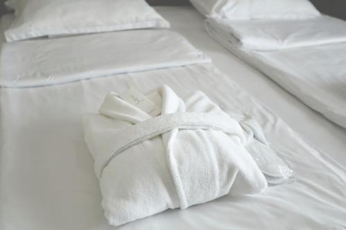 a pile of white towels on a bed at Hotel Homey Kobuleti in K'obulet'i