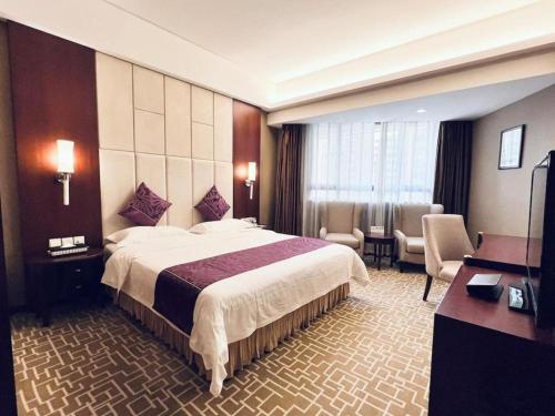 um quarto de hotel com uma cama grande e uma sala de estar em Century Plaza Hotel em Shenzhen