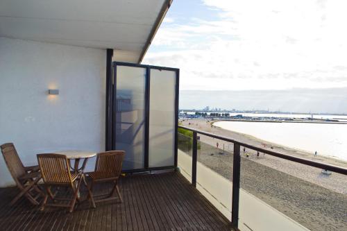 a balcony with a table and chairs and the beach at Pirita Sea View Apartments One bedroom in Tallinn