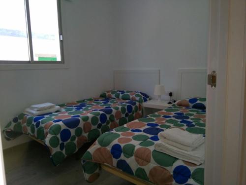 two beds sitting next to each other in a room at Apartamentos Noda in Playa de Santiago