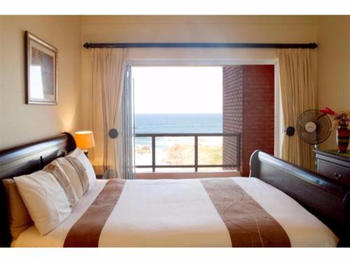 a bedroom with a bed with a view of the ocean at Balooga No. 36 in Margate
