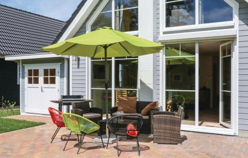 een patio met stoelen en een groene parasol bij Haus Hafenblick in Wandlitz