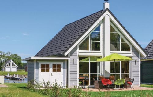 een huis met een schuin dak met stoelen en een parasol bij Haus Hafenblick in Wandlitz