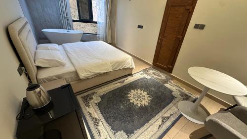a bedroom with a bed and a chair and a table at Bait Falaj Al Misfah Hospitality in Misfāh