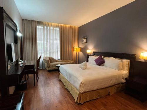 a hotel room with a bed and a desk at Kingston Hotel 18 - Kuala Lumpur Sri Damansara in Kuala Lumpur