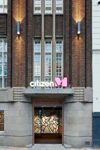 a building with two pink signs on top of it at citizenM Amstel Amsterdam in Amsterdam