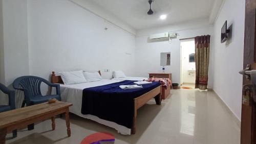 Un dormitorio con una cama y una silla dentro. en MALLICK PALACE NEIL Island, en Neil Island