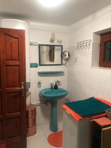 a bathroom with a green sink and a mirror at Blue House Apartman Kék Ház Üdülő in Dunapataj