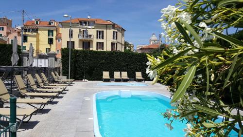 een zwembad met ligstoelen en een gebouw bij Riviera Palace Residence in Loano