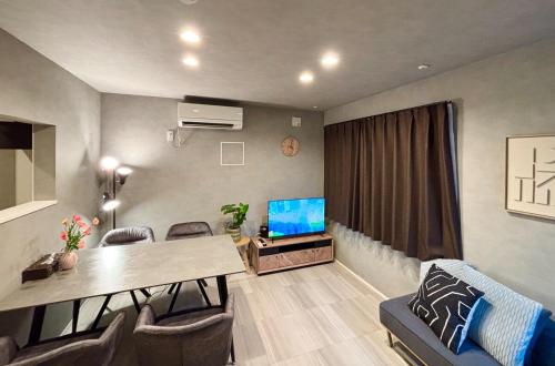 a living room with a dining table and a television at SALE Flawed Property with a loud music from neighbor but stay cheap in nice area in Tokyo