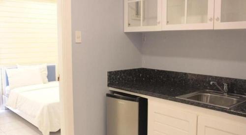 una cocina con fregadero y una cocina con cama en Moonbay Marina the Villas, en Olóngapo