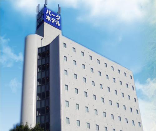 a white building with a blue sign on top of it at Niigata Park Hotel in Niigata