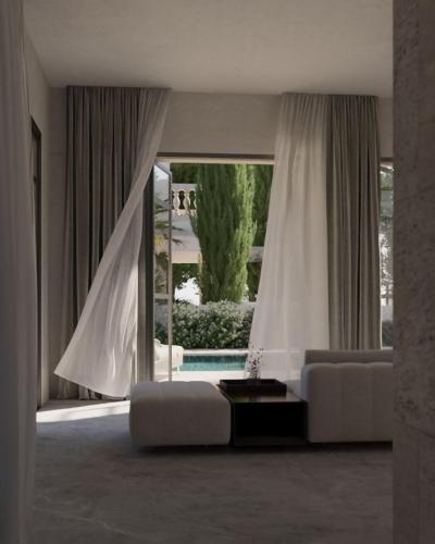a living room with a couch and a large window at Lantana Villas & Hotel in Peyia