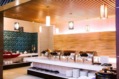 a restaurant with chairs and plates on a counter at The Golden Bay Hotel Batam in Sengkuang
