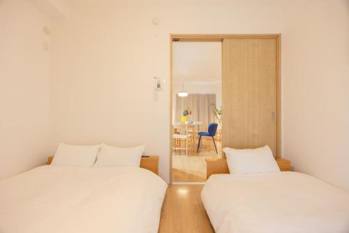 two beds in a room with a mirror at Nagoya Hanezu in Nagoya