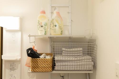 a shelf with milk bottles and towels in a bathroom at Nagoya Hanezu in Nagoya